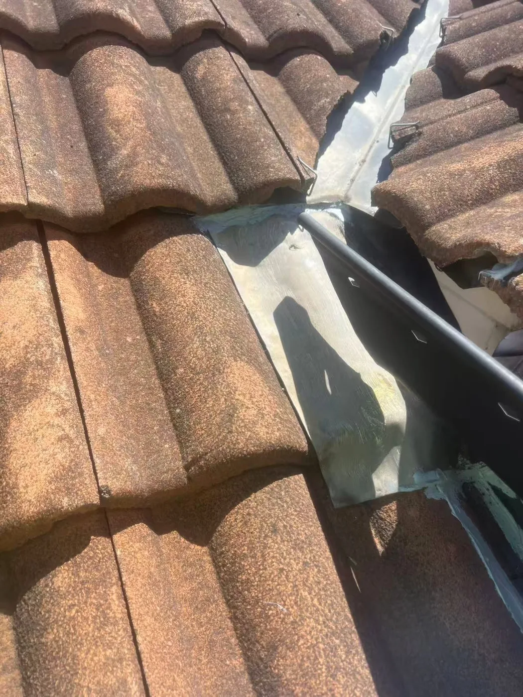 Roof valley flashing detail between tiled slopes