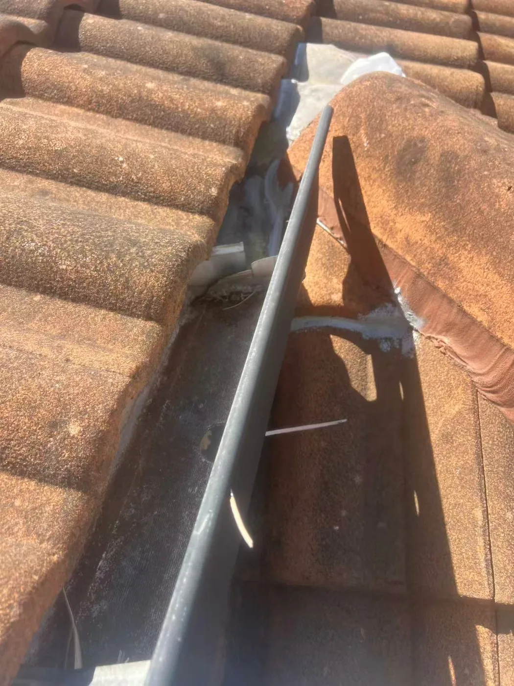Detailed view of valley flashing beneath tiles