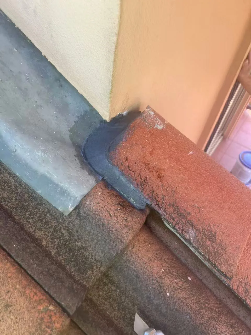Metal flashing along a wall and tiled roof