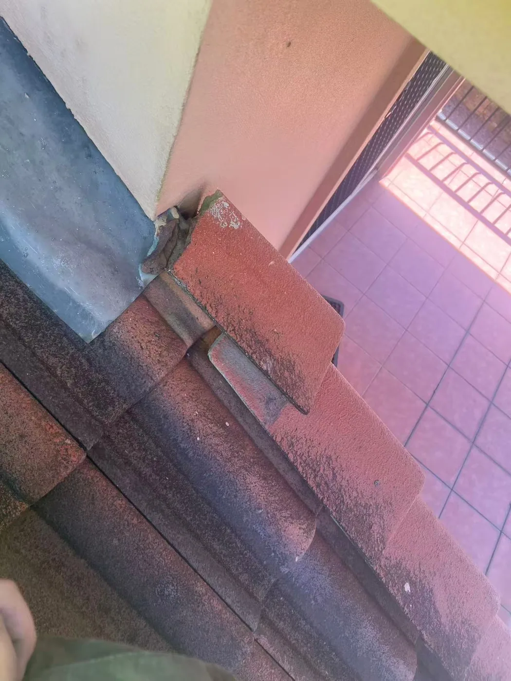 Close view of roof tiles meeting wall flashing